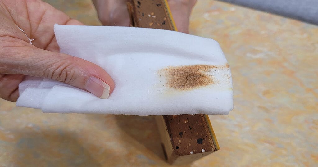 가보건강침대 황토침대 황토판 단면을 물티슈로 닦자 황토 입자가 묻어나는 모습-화학 접착제(바인더) 없이 천연 성형 공법으로 제작된 흙판의 직접적인 증거.   Kabobed Hwangto Board wipe test showing natural hwangto particles transferring without chemical binder — pure Korean loess construction.